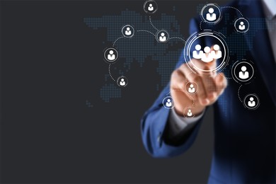 Image of Targeting, recruitment, customer acquisition. Businessman touching virtual screen with scheme of human icons and world map against dark grey background, closeup