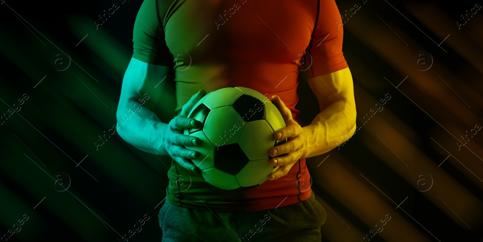 Image of Football player with soccer ball on black background in neon lights, closeup. Banner design. Stylish poster for sportive event