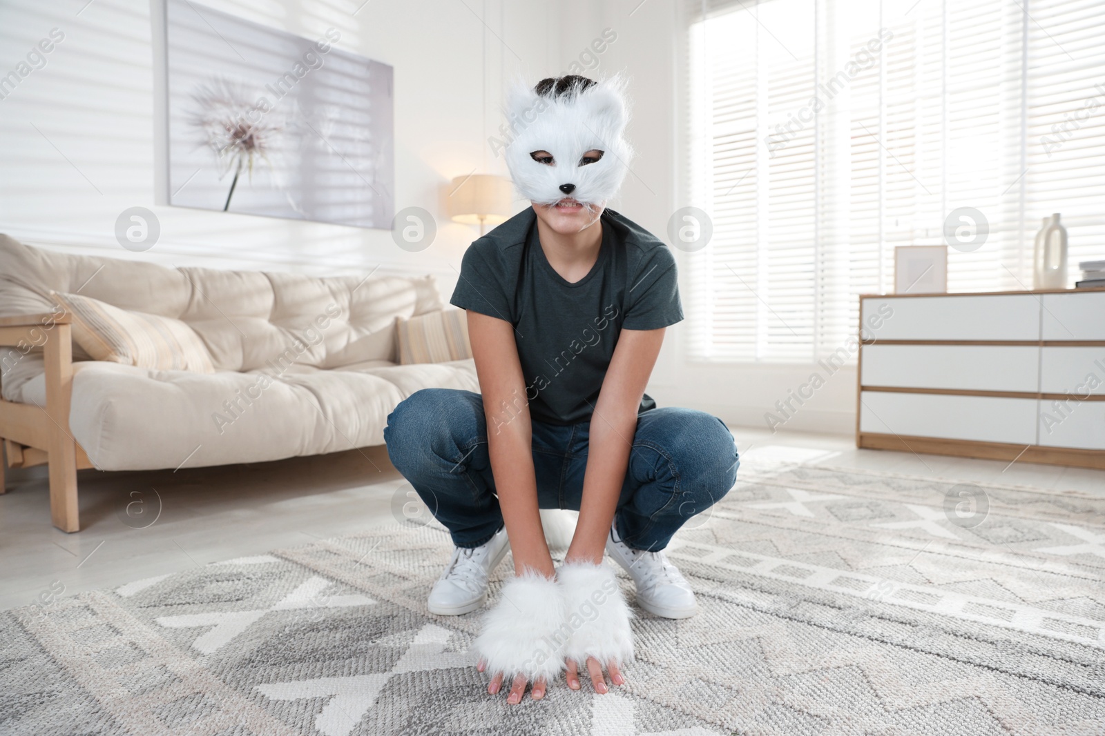 Photo of Quadrobics. Boy wearing cat mask and gloves at home