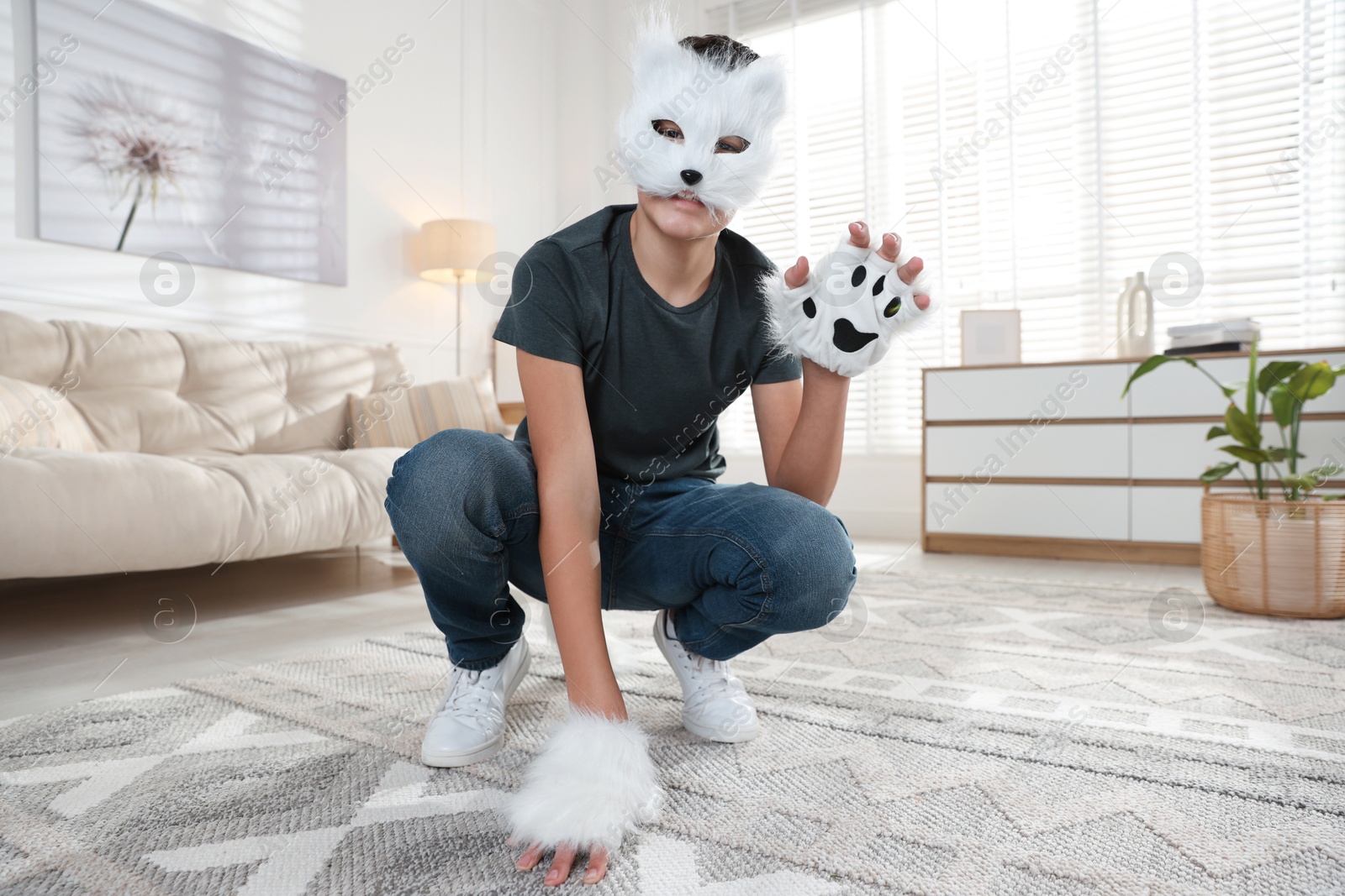 Photo of Quadrobics. Boy wearing cat mask and gloves at home