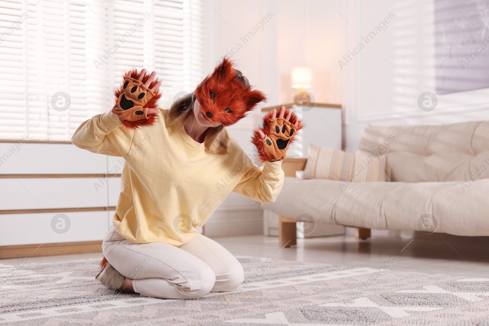 Photo of Quadrobics. Woman wearing fox mask and gloves at home