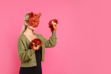 Photo of Quadrobics. Woman wearing fox mask and gloves on pink background, space for text