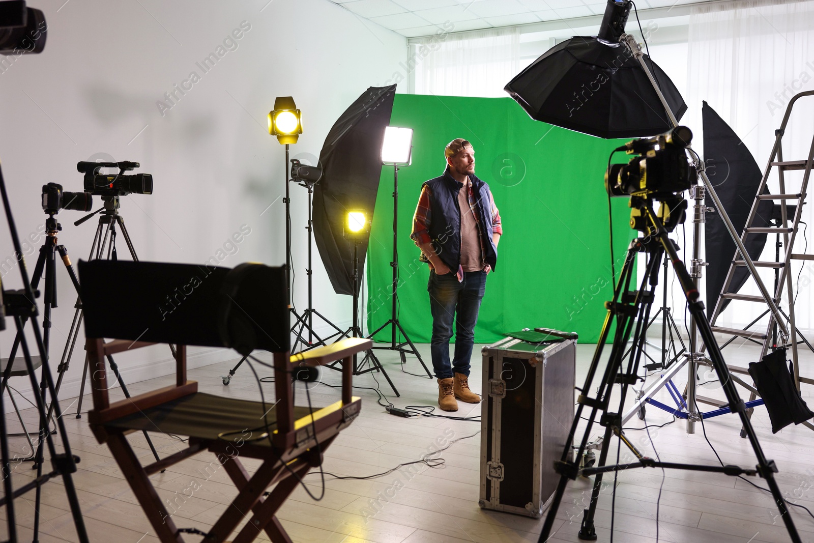 Photo of Man working in modern film studio with professional equipment