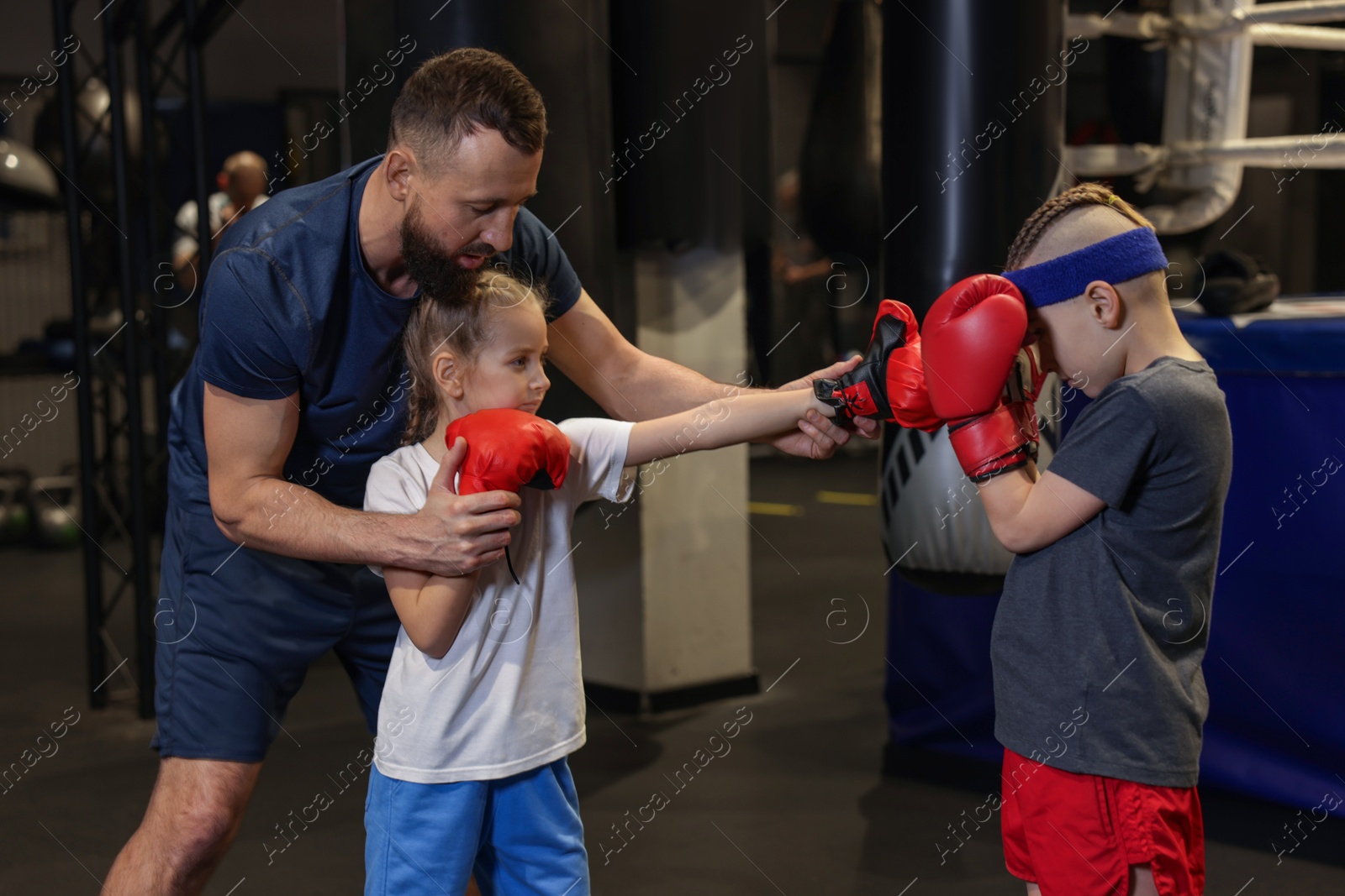 Photo of Boxing coach training children in sport center