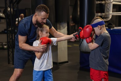 Photo of Boxing coach training children in sport center