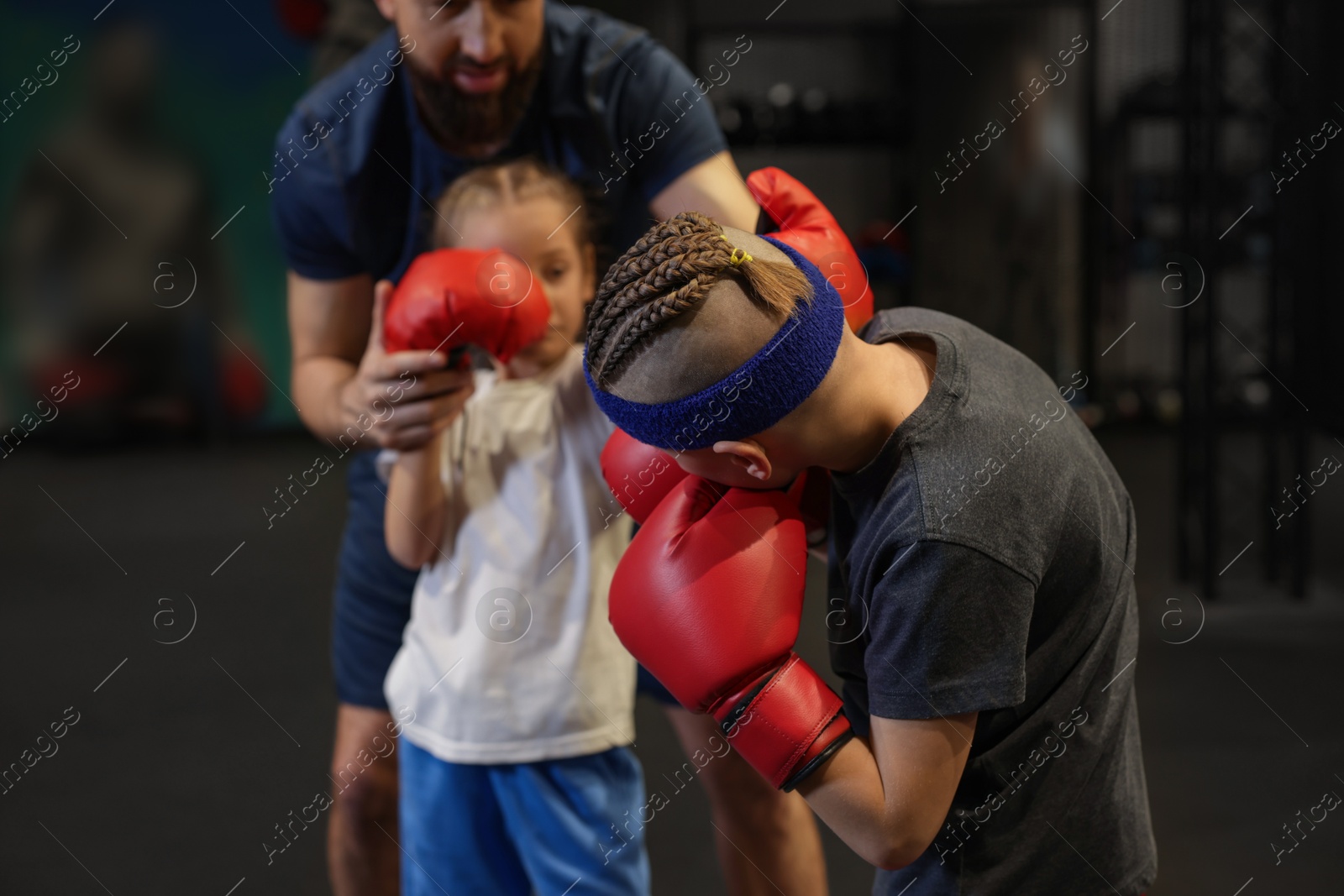 Photo of Children having boxing practice with their coach in training center