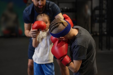 Photo of Children having boxing practice with their coach in training center