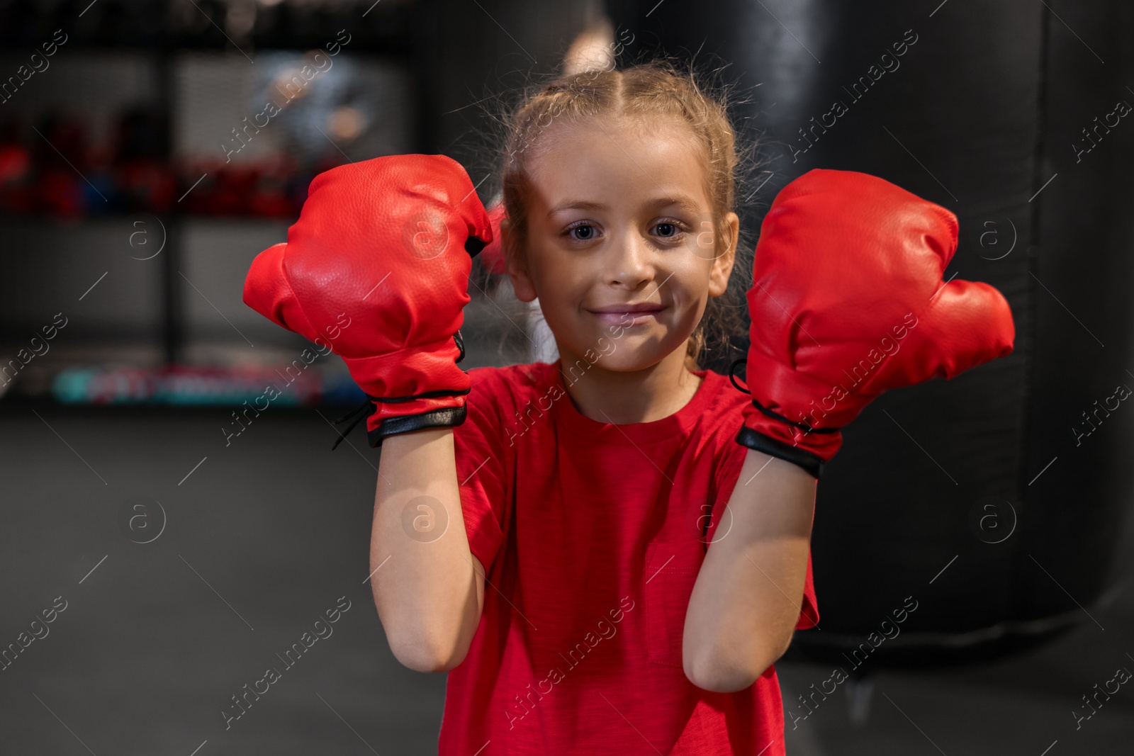 Photo of Boxing. Girl in protective gloves at training center