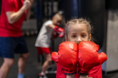 Photo of Girl in protective gloves during boxing practice at training center