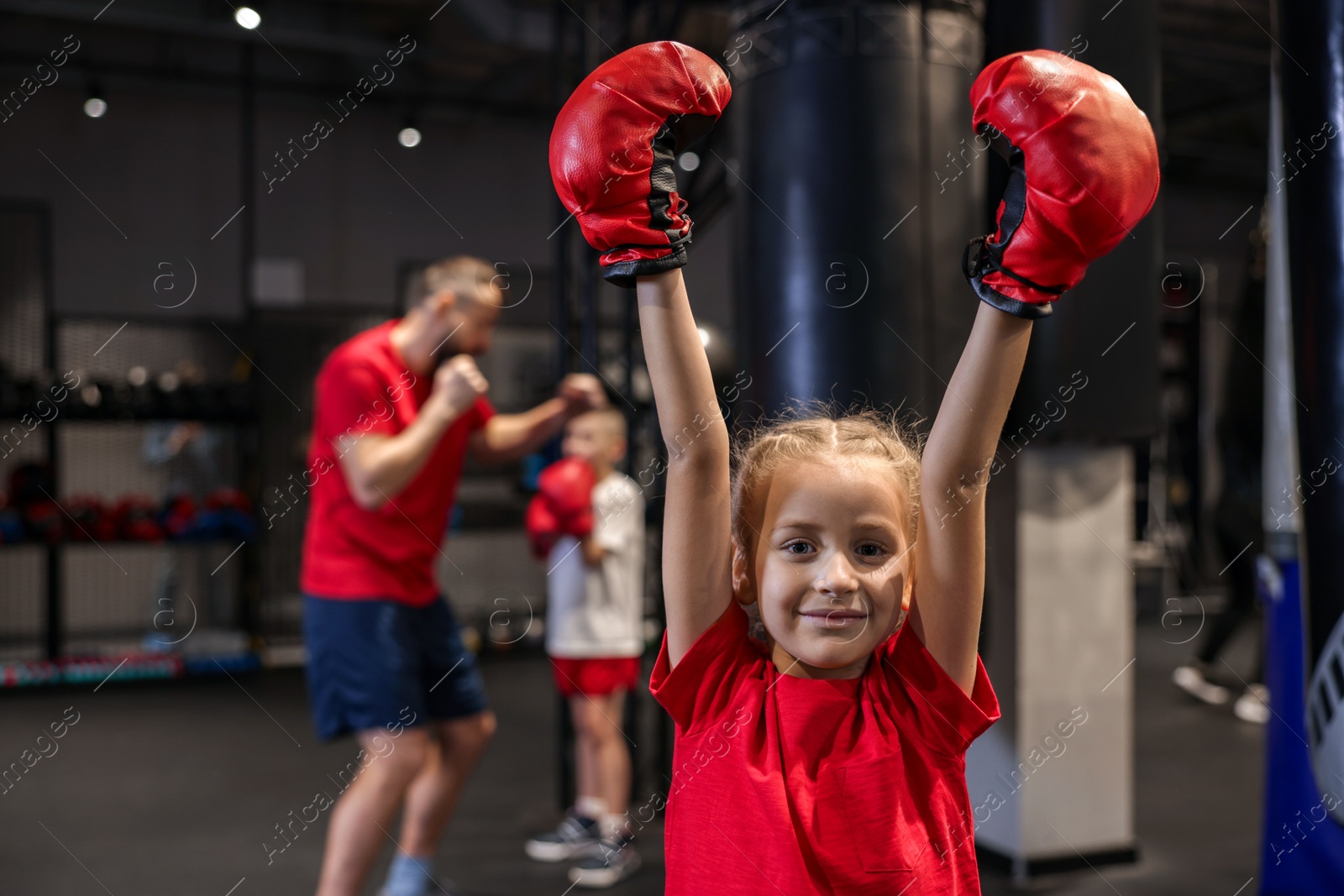 Photo of Girl in protective gloves during boxing practice at training center