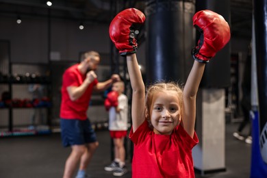 Photo of Girl in protective gloves during boxing practice at training center