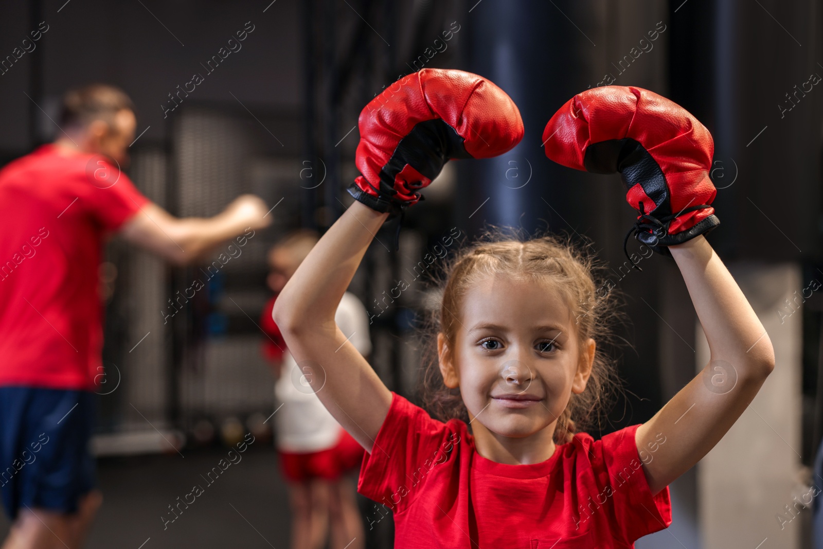 Photo of Girl in protective gloves during boxing practice at training center