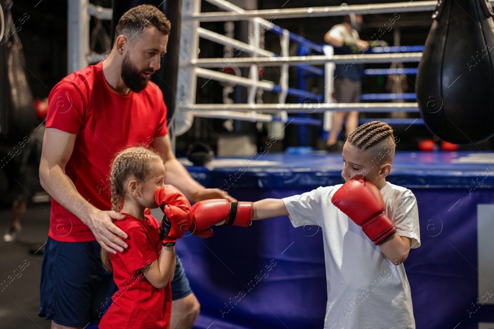 Photo of Boxing coach training children in sport center