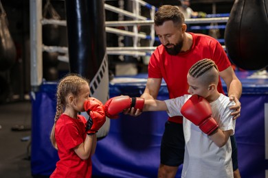 Boxing coach training children in sport center