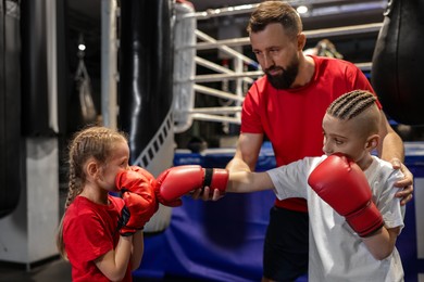 Boxing coach training children in sport center