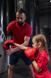 Boxing coach training girl in sport center