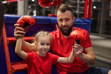 Happy girl with her coach near boxing ring