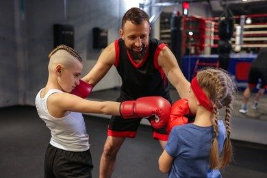 Boxing coach training children in sport center