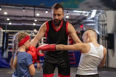 Photo of Boxing coach training children in sport center