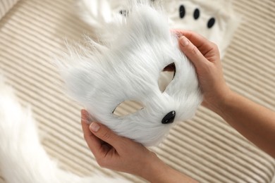 Photo of Quadrobics. Woman with furry cat mask near sofa, closeup