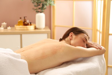 Woman undergoing body wraps treatment in spa salon