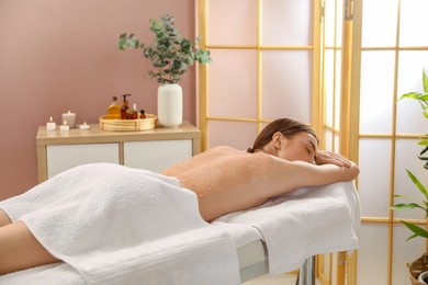 Woman undergoing body wraps treatment in spa salon