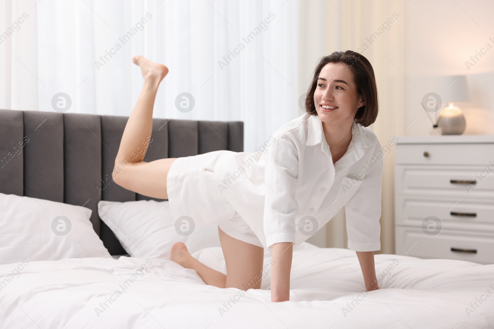 Photo of Young woman exercising on bed at home. Morning routine