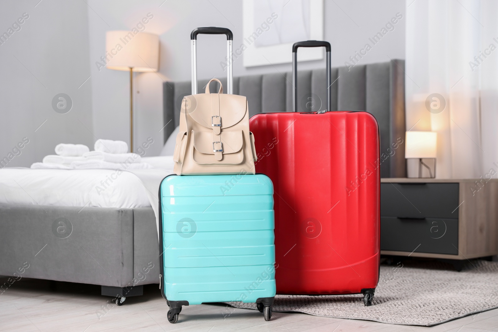 Photo of Stylish suitcases with backpack in hotel room