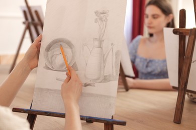 Woman with pencil learning to draw at table, closeup