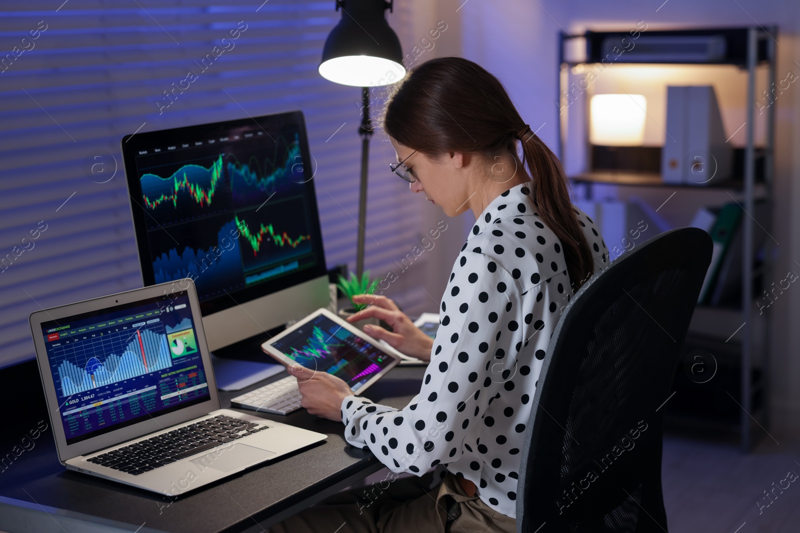 Photo of Stock exchange. Woman working in office at night