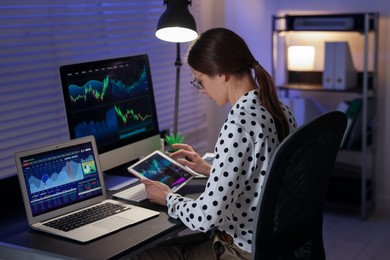 Photo of Stock exchange. Woman working in office at night