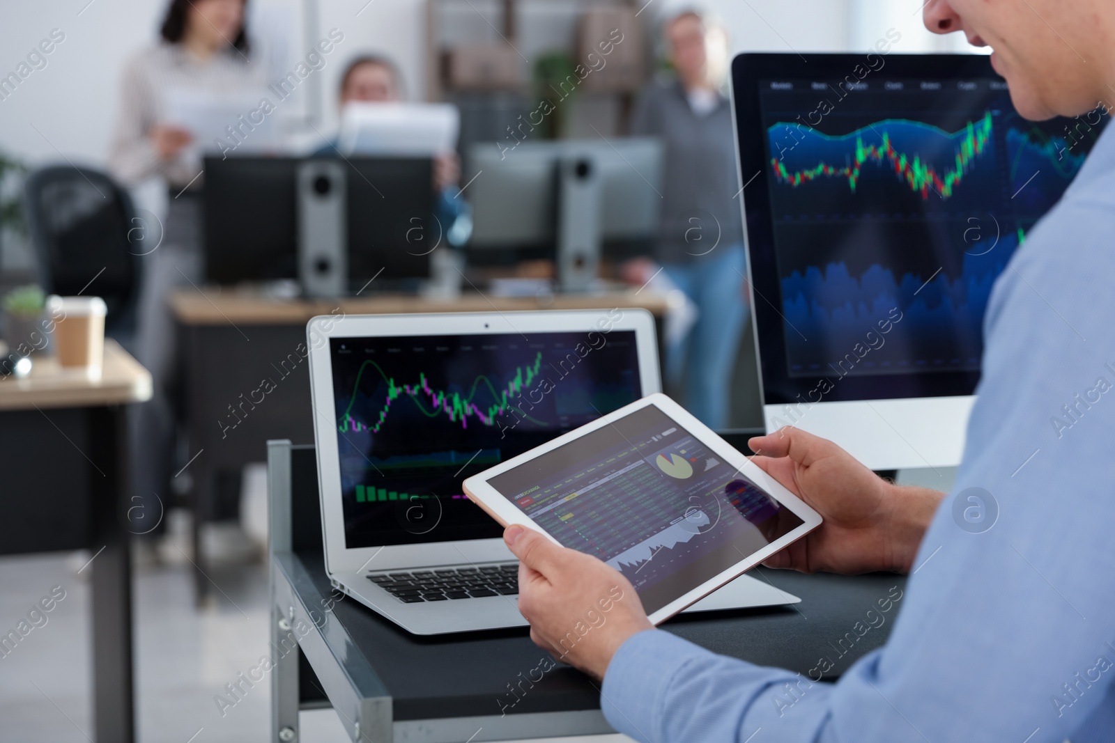 Photo of Stock exchange. Man working at desk in office, closeup