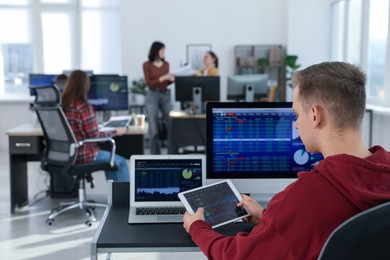 Photo of Stock exchange. Man working at desk in office