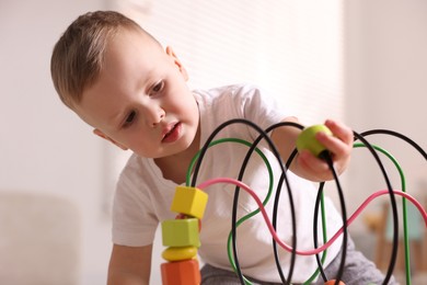 Photo of Motor skills development. Little boy playing with toy at home