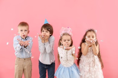 Photo of Children with confetti on pink background. Birthday surprise party