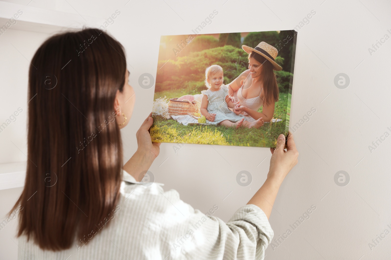 Photo of Canvas print. Woman hanging photo on wall at home