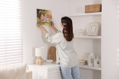 Photo of Canvas print. Woman hanging photo on wall at home