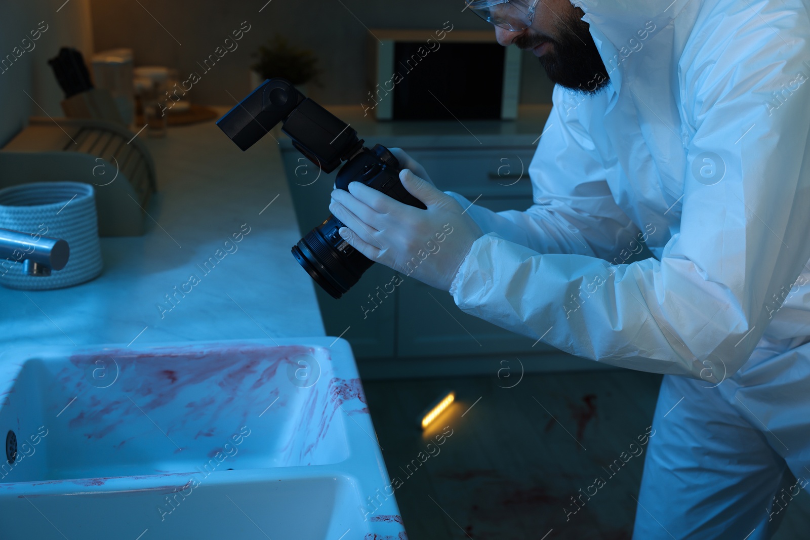 Photo of Forensic expert with camera working at crime scene indoors, closeup