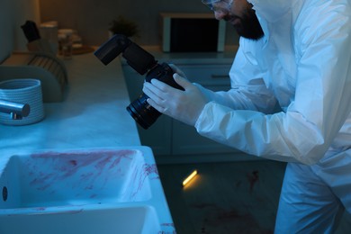 Forensic expert with camera working at crime scene indoors, closeup