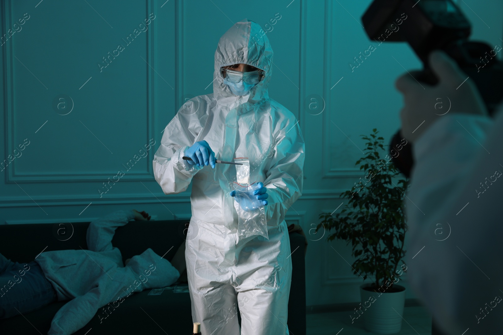 Photo of Forensic experts working at crime scene with dead woman's body indoors, closeup