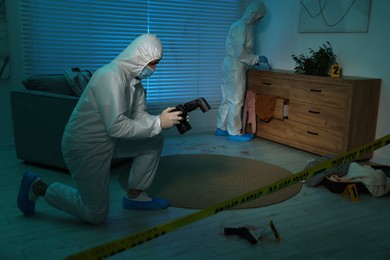 Forensic experts working at crime scene indoors