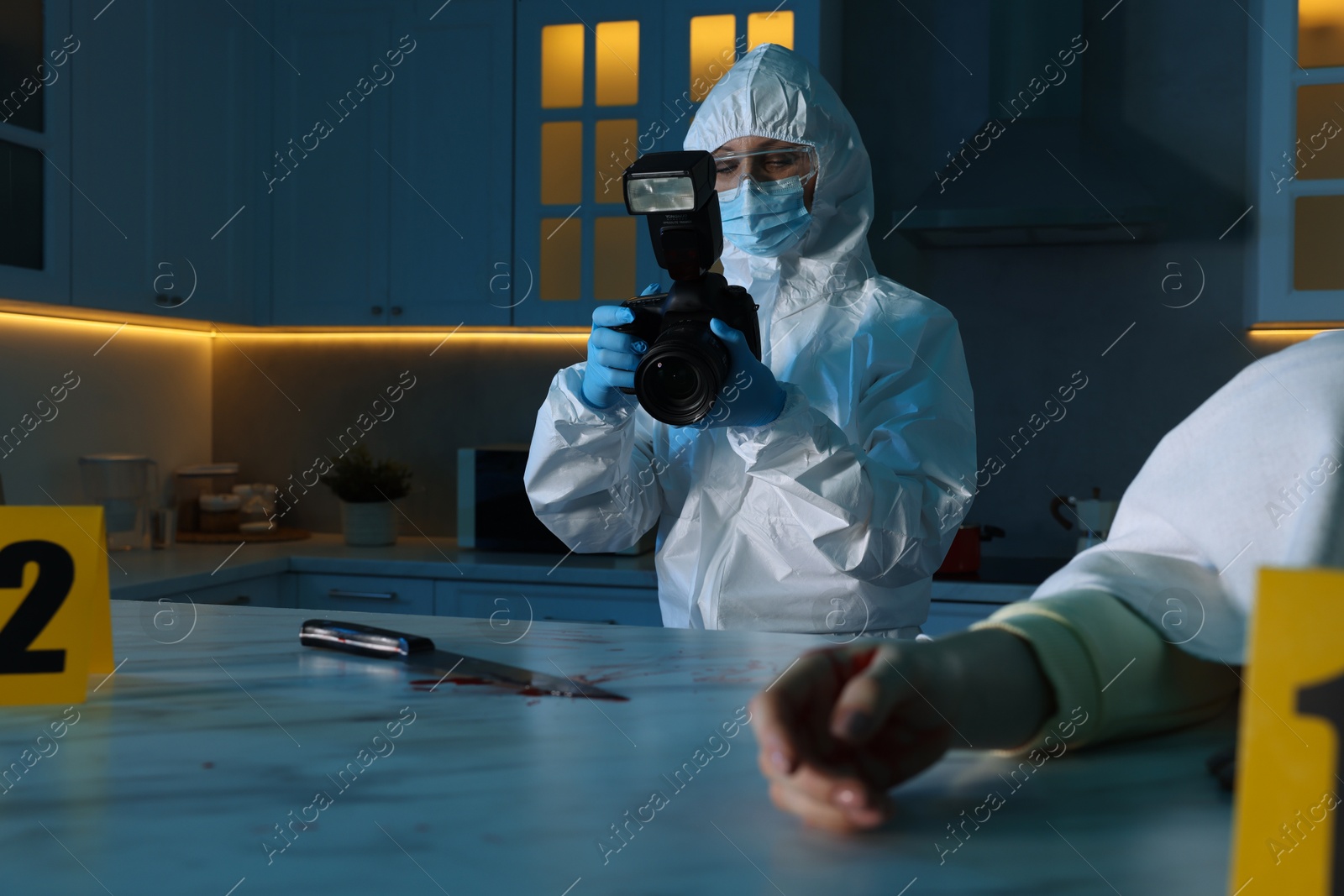 Photo of Forensic expert with camera working at crime scene and dead woman's body indoors, selective focus