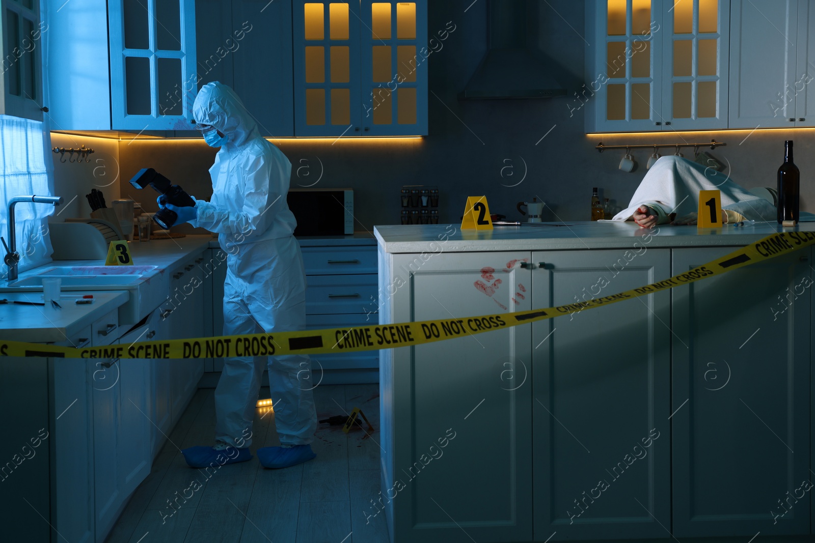 Photo of Forensic expert with camera working at crime scene and dead woman's body in dark room