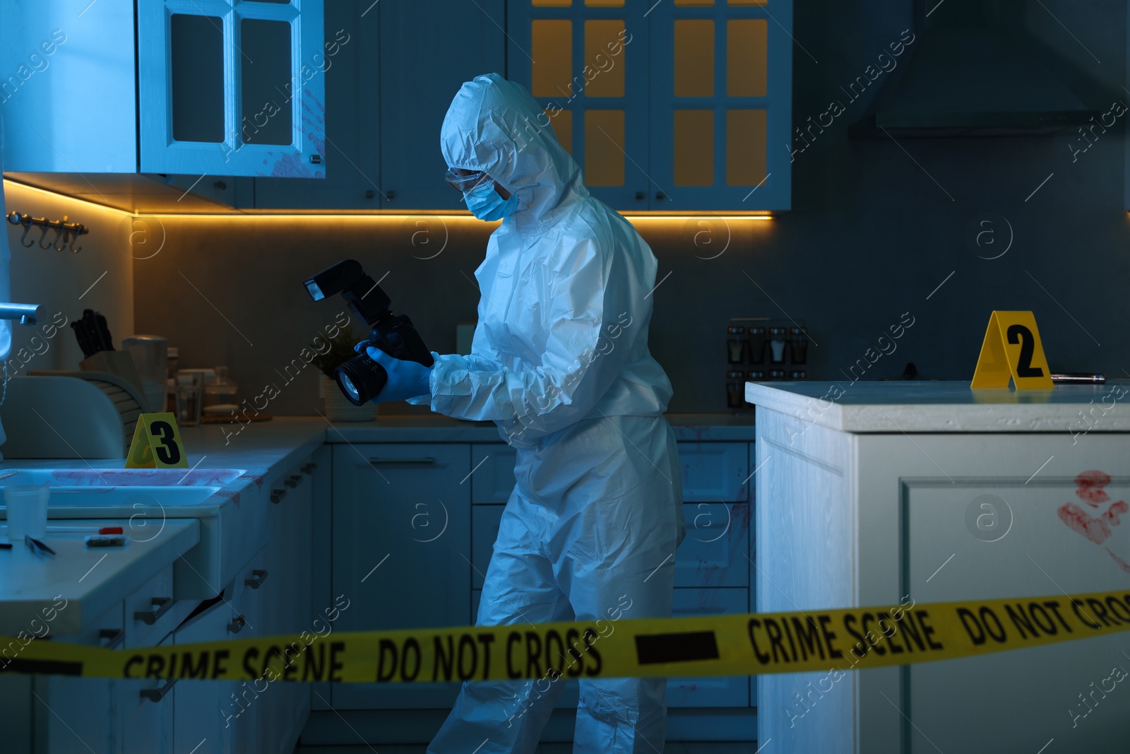 Photo of Forensic expert with camera working at crime scene in dark room