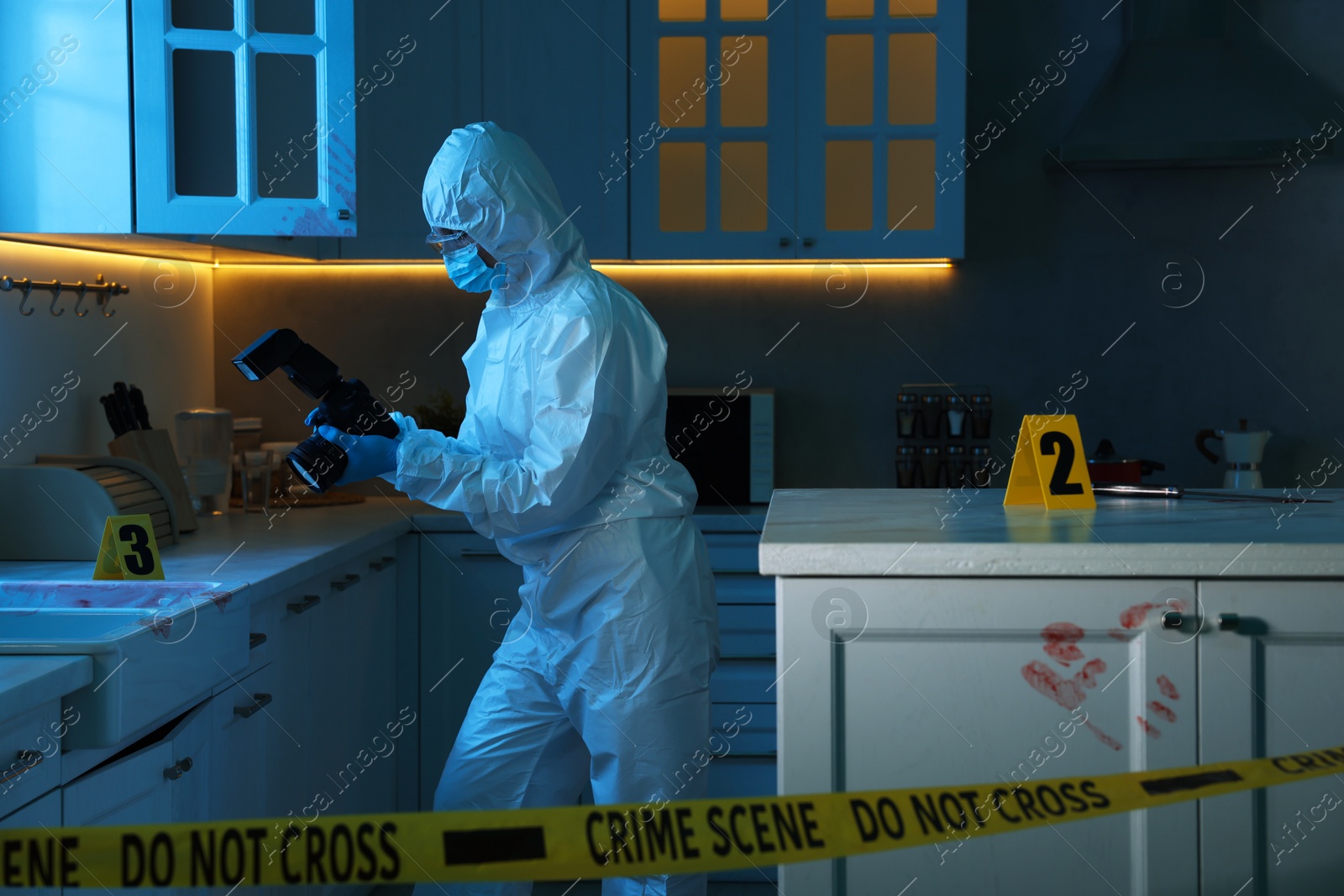 Photo of Forensic expert with camera working at crime scene in dark room