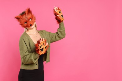 Photo of Quadrobics. Woman wearing fox mask and gloves on pink background, space for text