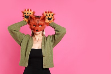 Photo of Quadrobics. Woman wearing fox mask and gloves on pink background, space for text