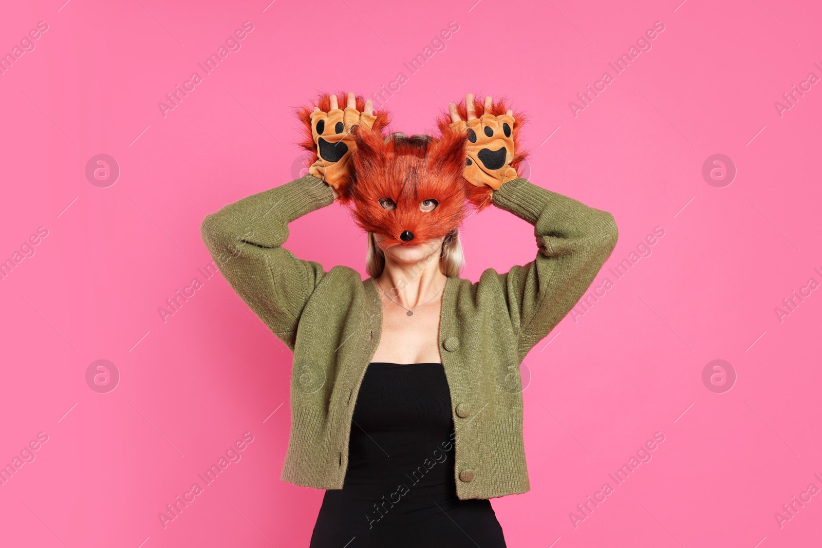 Photo of Quadrobics. Woman wearing fox mask and gloves on pink background