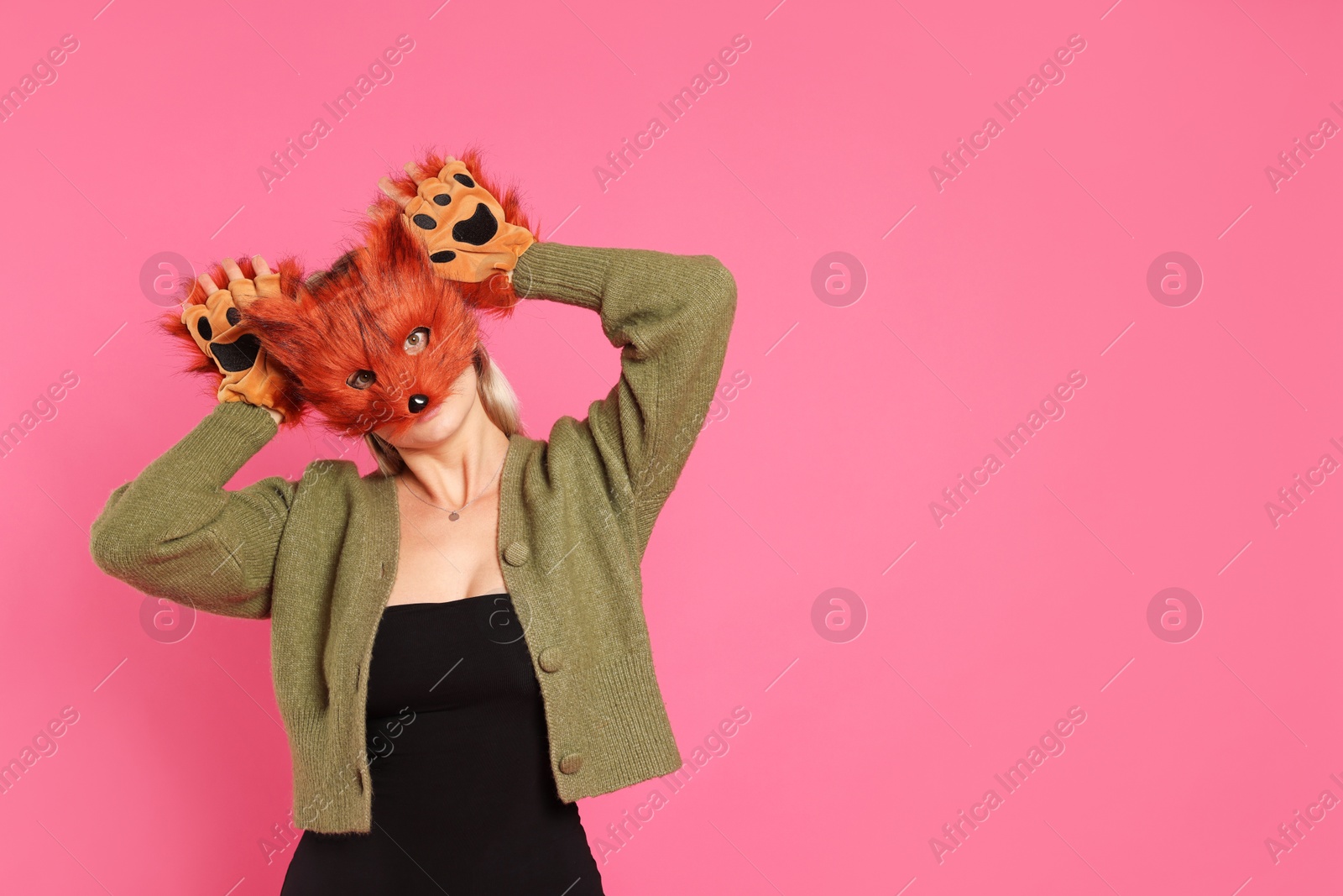 Photo of Quadrobics. Woman wearing fox mask and gloves on pink background, space for text