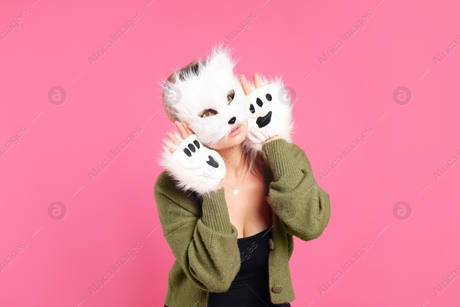 Photo of Quadrobics. Woman wearing cat mask and gloves on pink background